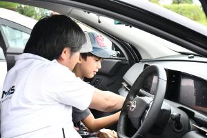 EV自動車に乗って説明を受ける男の子