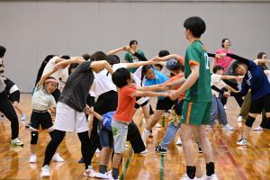 両手を取り合いストレッチするイベント参加者
