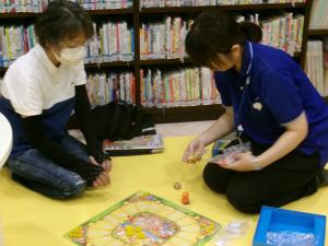 大人の参加者の方と図書館スタッフがゲームで遊んでいる写真