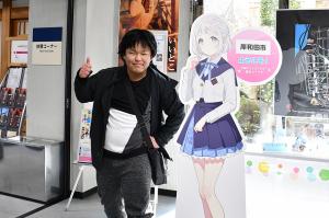 葛城リーリヤのパネルと一緒に写る男性