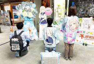 パネルと一緒に写る法被姿の後ろ姿の人たち