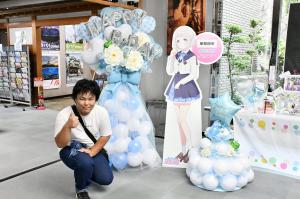 パネルと一緒に写る男性
