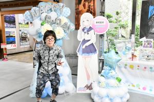 パネルと一緒に写る男性