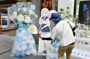 パネルと一緒に写る男性