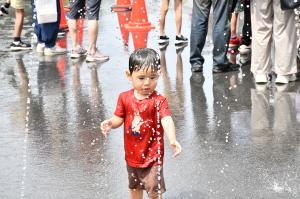 暑さ対策のための噴水で遊ぶ全身ずぶ濡れの男の子