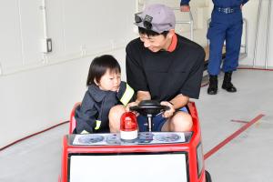 消防ミニカーに乗る親子