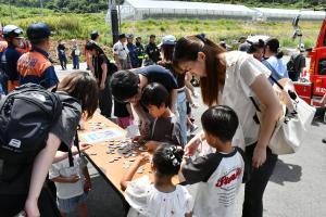 出口で参加者プレゼントの缶バッジを選ぶ親子