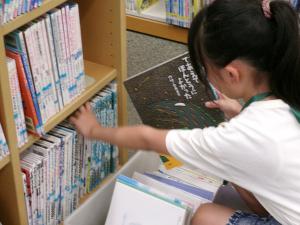 返却された本を本棚に戻している様子
