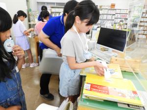 カウンターで資料の貸出、返却をしている様子