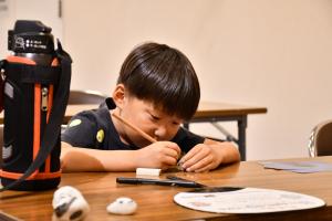 石ころに絵を描く男の子
