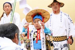 ぶちで除くようなしぐさをする男の子