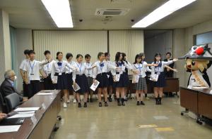 左手を伸ばし歌唱する学生たち