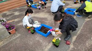 子供たちがバスケットに花を植えている様子