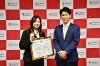 賞状とメダルを持って市長と記念撮影をする豊島さん